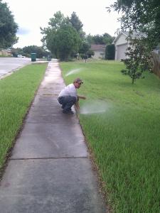 checking a sprinkler head during a regular sprinkler repair in Weston, Florida